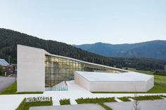 the building is surrounded by mountains and grass