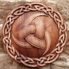 a wooden plaque with an intertwined knot on it