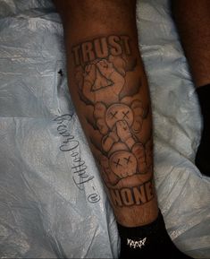 a man with a tattoo on his leg that says trust none