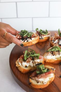 a person reaching for some food on a wooden platter