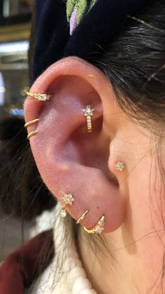 a woman wearing ear piercings with cross designs on the top and bottom of her ear