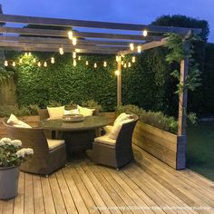 an outdoor dining area is lit up with string lights and wicker furniture for seating