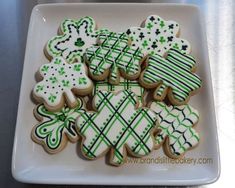 some decorated cookies on a white plate with green and white designs in the shape of shamrocks