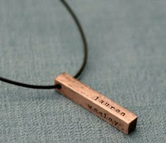 a necklace with the word lauren galaxy engraved on it's back and a cord attached to it