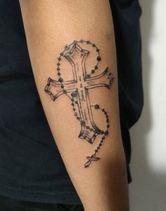 a cross tattoo on the arm