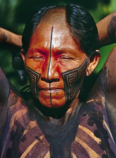 a native american man with painted on his face and chest is posing for the camera