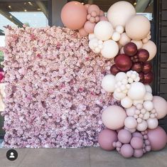 an arrangement of balloons and flowers in front of a building