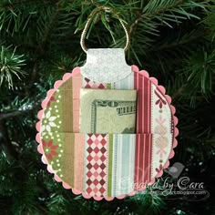 an ornament hanging from a christmas tree with money on it's side