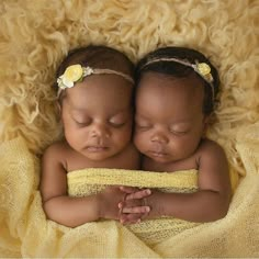 two babies are sleeping on a yellow blanket with their eyes closed and one is holding the other's head