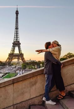 a man and woman kissing in front of the eiffel tower, paris france