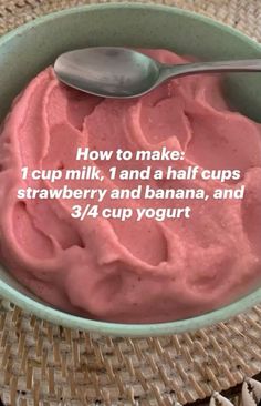 a bowl filled with strawberry yogurt next to a spoon