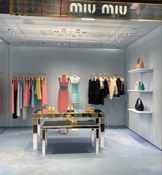 a clothing store display with clothes on racks and mannequins in the background