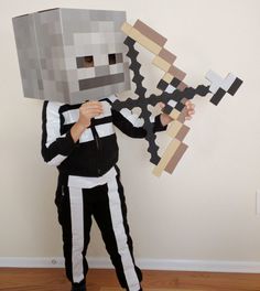 a person in a minecraft costume holding up a paper cut out of a block