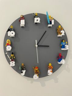 a clock made out of legos with numbers and figures on the face is shown