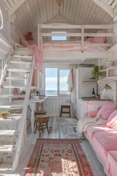 a loft bed with stairs leading up to the top floor and a pink couch in front of it