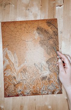 a person is drawing on a piece of wood