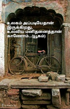 an old bicycle is parked in front of a stone building with a quote written on it