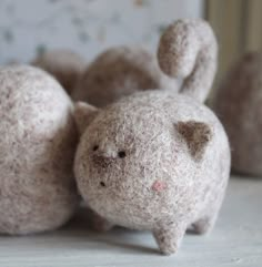 there is a small stuffed animal that looks like a cat on the floor next to two smaller ones