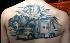 the back of a man's shoulder with a truck and mountains in the background