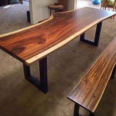 a wooden table with two benches next to it in a living room filled with furniture