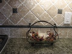 a glass bowl filled with flowers sitting on top of a counter next to a light switch