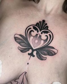 a woman's chest with a tattoo design on the top part of her breast