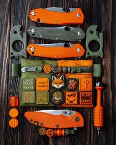 an assortment of knives and tools laid out on top of each other with orange handles