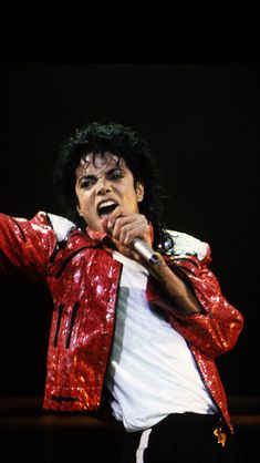 michael jackson performing on stage with his red jacket over his face and black pants,