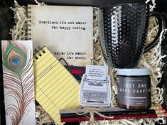 an open box containing books, notebooks, and a cup with writing on it