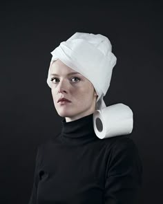 a woman with a white towel on her head is wearing a black turtle neck sweater