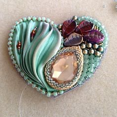 a heart shaped brooch sitting on top of a table