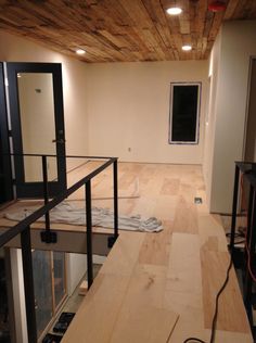 an unfinished room with wood floors and glass railings