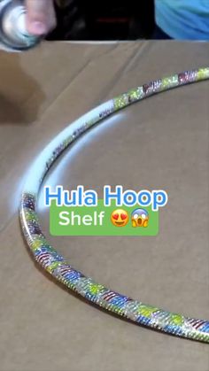 a close up of a person holding a cell phone near a box with the words hula hoop on it