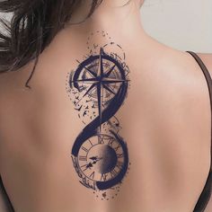 the back of a woman's neck with a compass tattoo on it