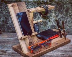 a wooden stand with glasses, cell phone and wallet on it