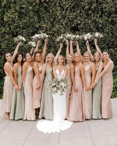 a group of women standing next to each other holding bouquets in front of them