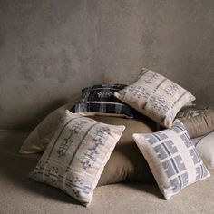 four pillows stacked on top of each other in front of a gray wall and floor