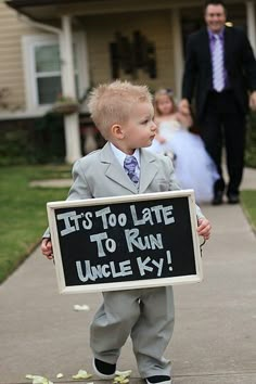 a little boy holding a sign that says it's too late to run uncle ky