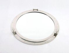 a mirror that is sitting on a white surface in the shape of a boat's porthole