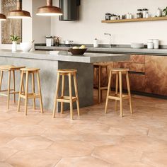 three stools sit in front of a kitchen island