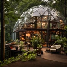 a glass dome house surrounded by trees and plants in the middle of a wooded area