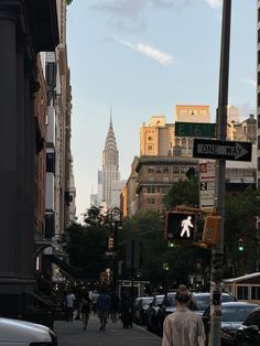 people walking down the street in front of tall buildings