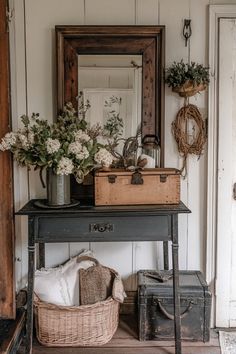 an old suitcase sitting on top of a wooden table next to a basket with flowers