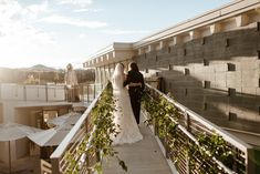 a bride and groom standing on a balcony