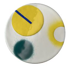 a white plate with yellow and blue circles on it's side, against a white background