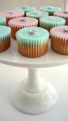 cupcakes with frosting sitting on a cake plate