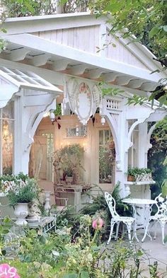 a white gazebo sitting in the middle of a garden