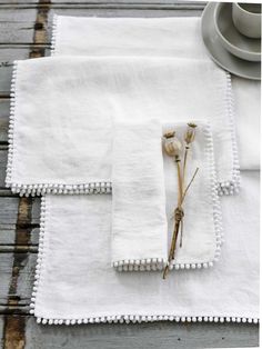 white linen napkins with pom poms on them