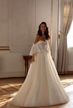 a woman in a white wedding dress posing for the camera