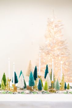 a table topped with christmas trees and candles